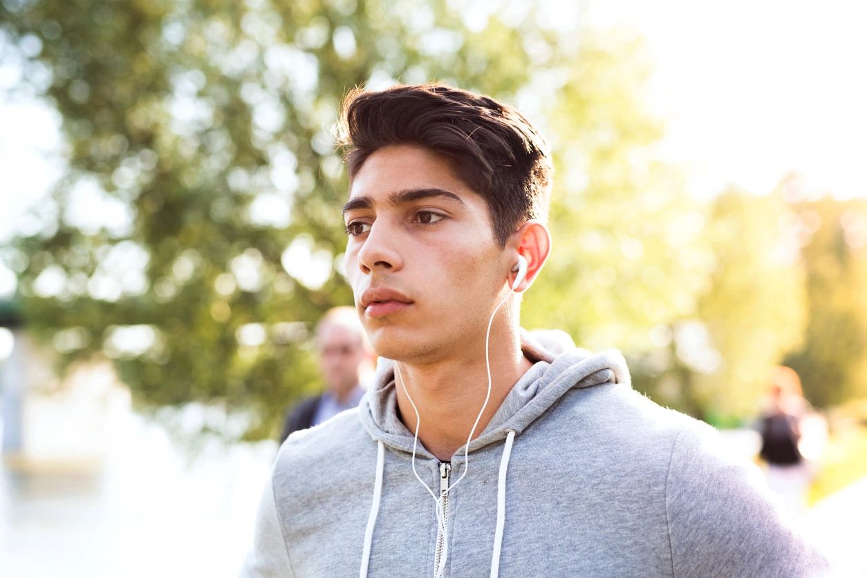 A man with headphones on looking at the camera.